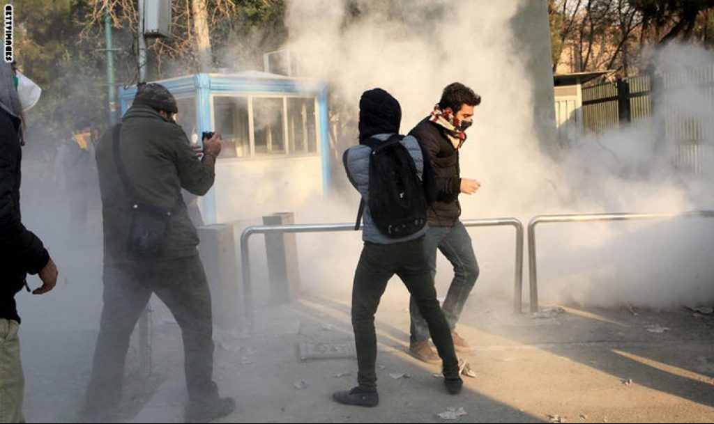 Iranian students run for cover from tear gas at the University of Tehran during a demonstration driven by anger over economic problems, in the capital Tehran on December 30, 2017. 
Students protested in a third day of demonstrations, videos on social media showed, but were outnumbered by counter-demonstrators.  / AFP PHOTO / STR        (Photo credit should read STR/AFP/Getty Images)